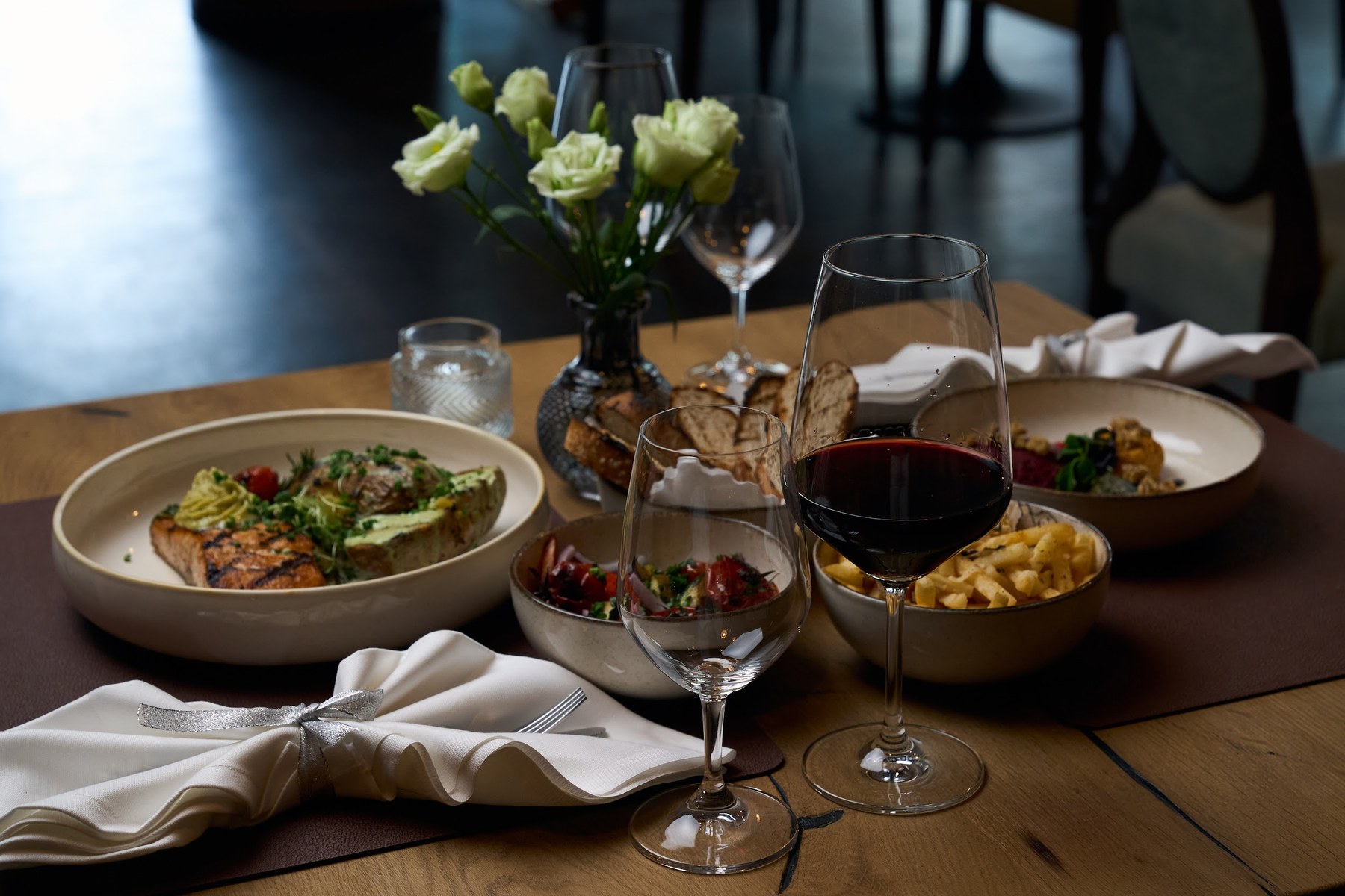 Elegant gedeckter Tisch mit Rotwein und Lachs im Tamare