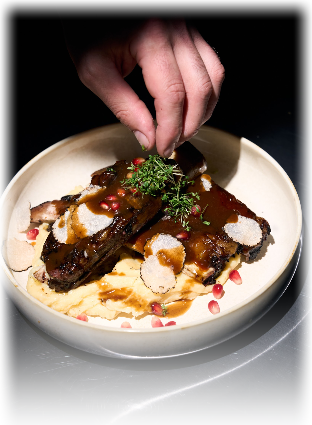 Wagyu Short Ribs werden angerichtet – Granatapfeljus und Trüffel